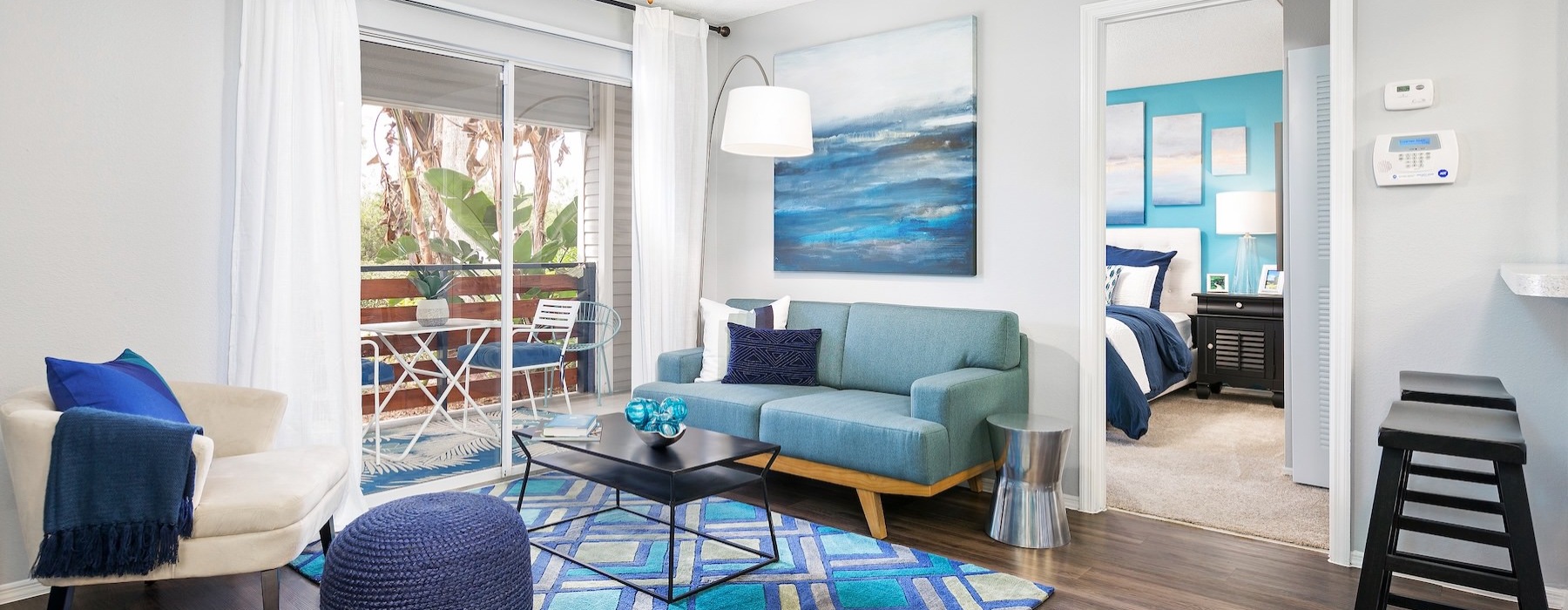 a living room with a blue couch and a fan