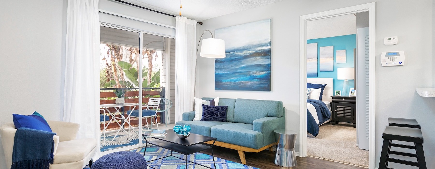 a living room with a blue couch and a fan